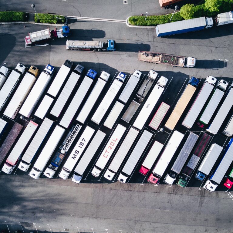 Many trucks in a large yard.